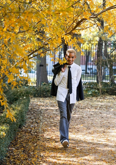 Photo modern beautiful young man walking and enjoying the nature in the park vertical photo