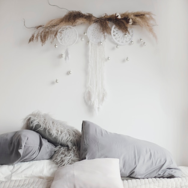 사진 베개가 있는 아늑한 침대가 있는 스칸디나비아 스타일의 현대적인 침실 인테리어