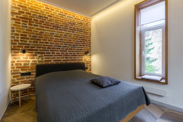Foto camera da letto moderna in stile loft con letto grande in colore scuro
