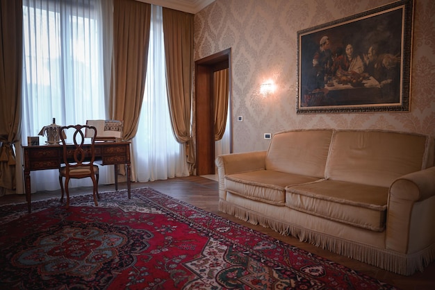 現代的なベージュ色のソファと,ハードウッドの床とエリアのカーペットを持つスタイリッシュなリビングルームの絵画