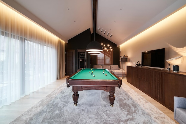 Modern billiard room with a beautiful table and large windows