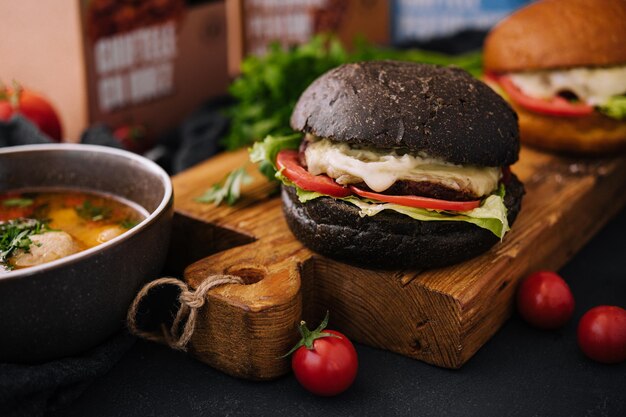 Modern black burger on wooden board