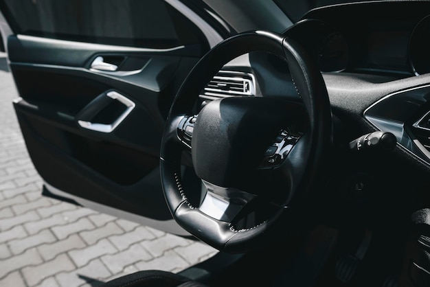 Фото Современный черный салон автомобиля, кожаный руль, климат-контроль, навигация, воздуховоды, дефлектор