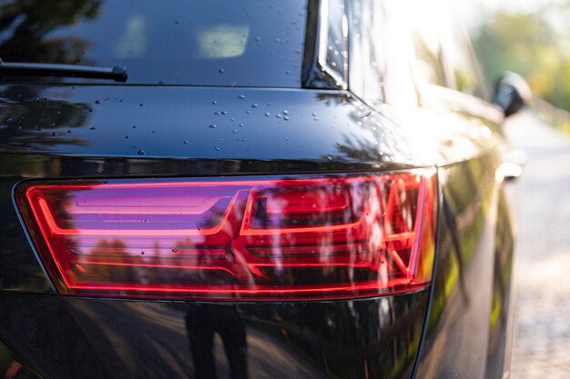 Parcheggio nero moderno sulla strada primo piano dettaglio dei fari