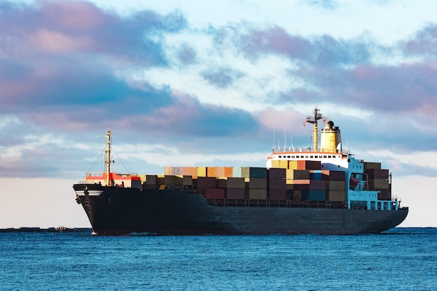 Modern black container ship moving from Baltic sea