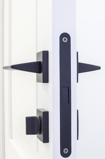 Modern black door handle on white wooden door in interior Knob closeup elements Door handle fittings for interior design