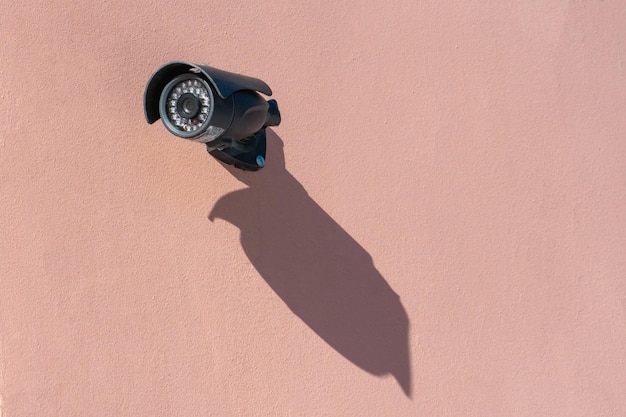 A modern black surveillance camera mounted on the wall closeup\
security and theft protection systems protection of private\
territory the banking system and personal belongings