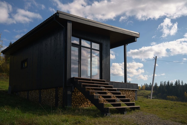 Photo modern black wooden house with big windows on carpathian mountains in ukraine with copy space