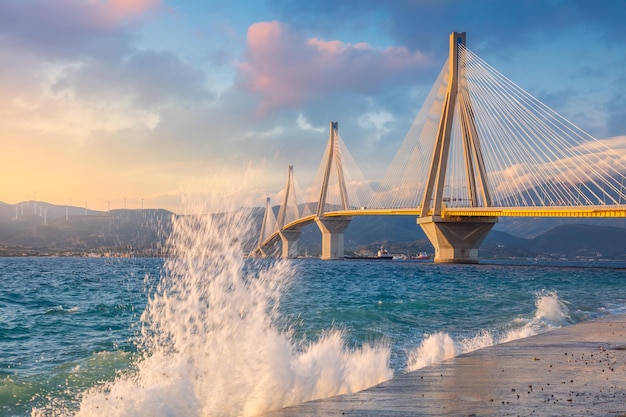 파도가 튀는 저녁 일몰 시간에 현대 다리 RionAntirion Bridge Greece Europe