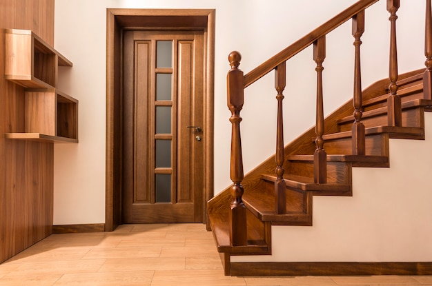 Photo modern brown oak wooden stairs  and doors in new renovated house interior