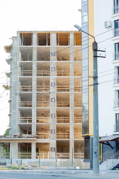 Edificio moderno in costruzione con dettagli in cemento armato indow aperture e impalcature