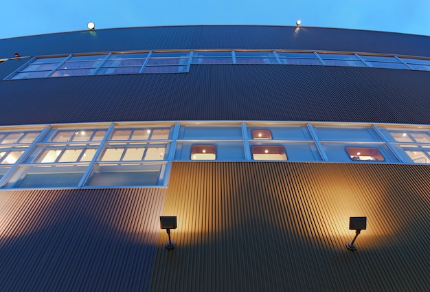 Modern building exterior abstract architectural background at twilight time with yellow illumination and blue sky, Tokyo Japan