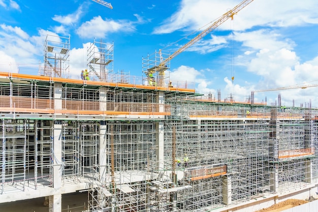 Modern building is under construction, metal scaffolding and blue sky