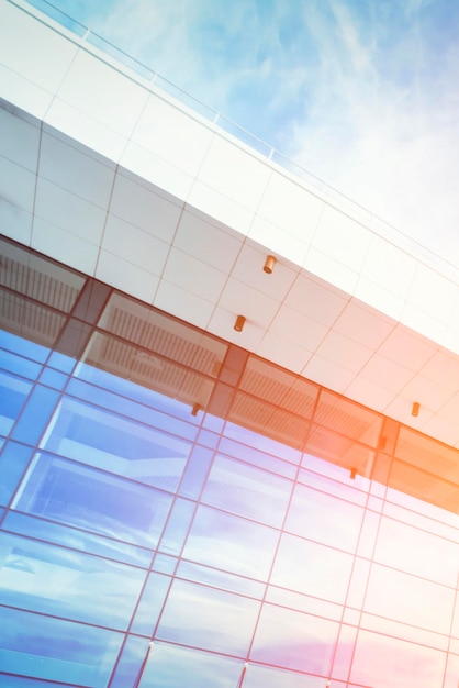 Modern building with a blue glass facade against the sky in the sunlight