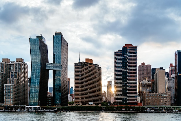 Modern buildings by river against sky in city