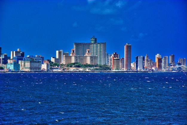 Photo modern buildings by sea against blue sky