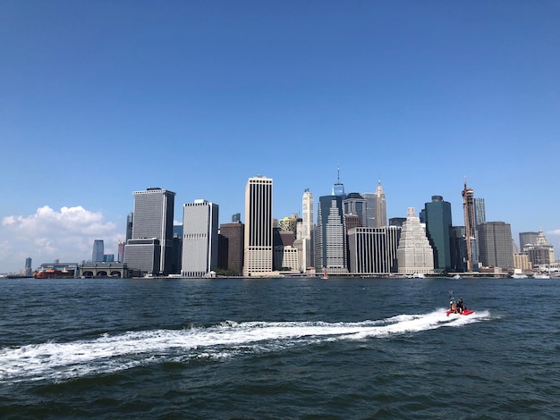 Modern buildings by sea against clear sky