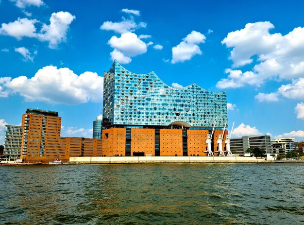 Modern buildings by sea against sky in city