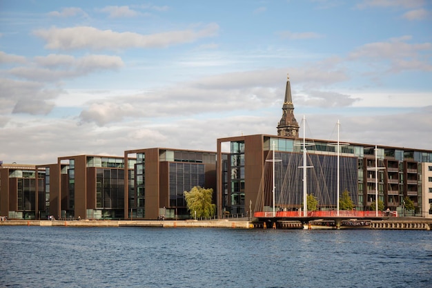 Modern buildings and church tower along side the Copenhagen harbor canal