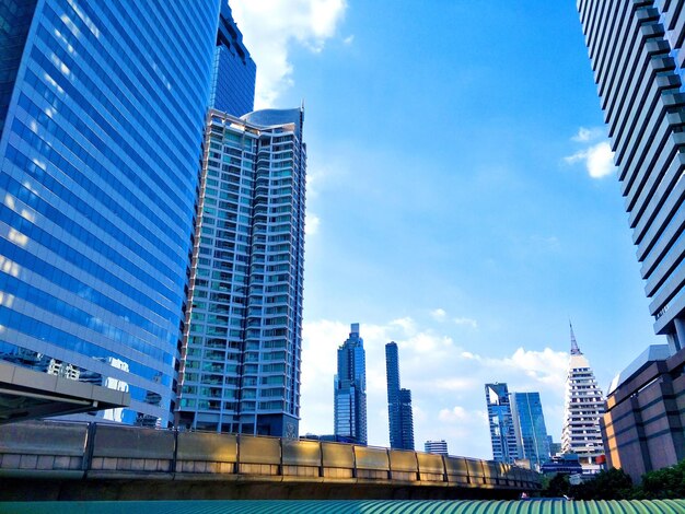 Modern buildings in city against blue sky