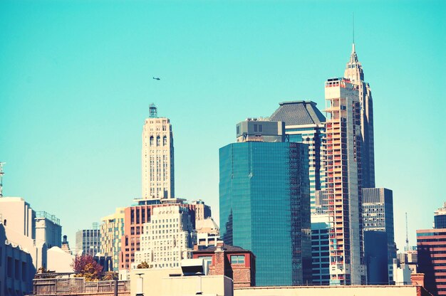 Modern buildings in city against clear blue sky