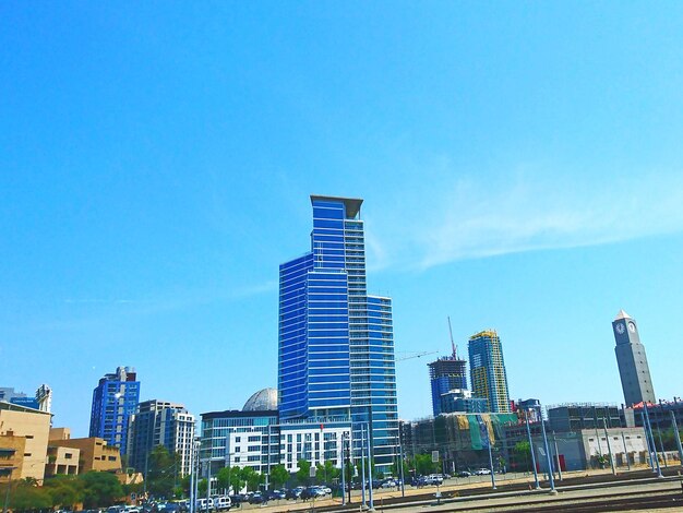 Modern buildings in city against clear blue sky