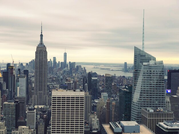 Modern buildings in city against cloudy sky