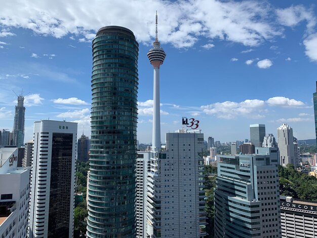 Modern buildings in city against cloudy sky