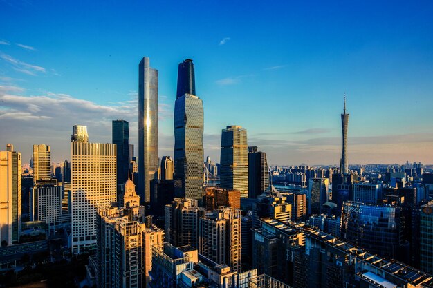 Modern buildings in city against sky during sunset