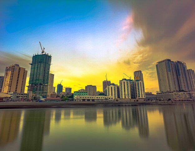 Modern buildings in city against sky during sunset