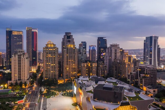 Modern buildings in city against sky at dusk