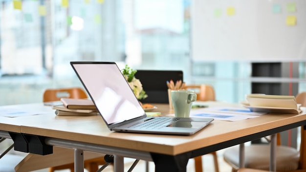 Modern bureau met notebook laptop op houten tafel in kantoorruimte