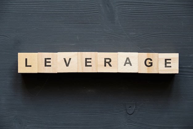 Photo modern business buzzword - leverage. top view on wooden table with blocks. top view.