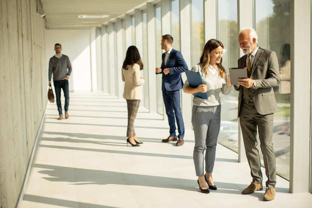 Modern business people using digital tablet in the office corridor