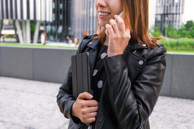 Modern business woman talking on the smart phone near the business center