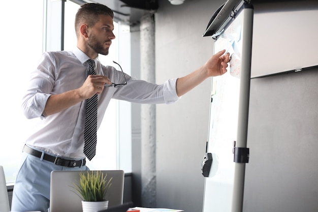 Modern businessman is using flipchart in the office.