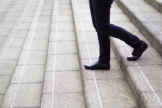 Foto gambe moderne dell'uomo d'affari che camminano giù per le scale concetto di decisione di investimento aziendale