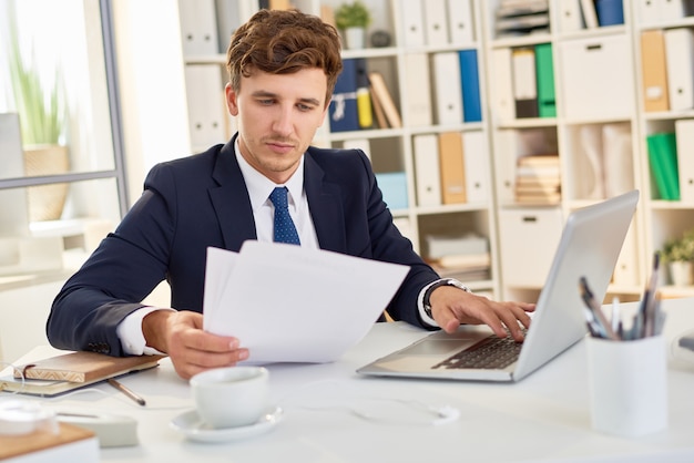 Современный бизнесмен читает документы в офисе