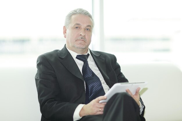 Modern businessman sitting in office lobbypeople and technology