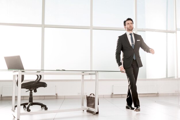 Modern businessman standing in a bright office