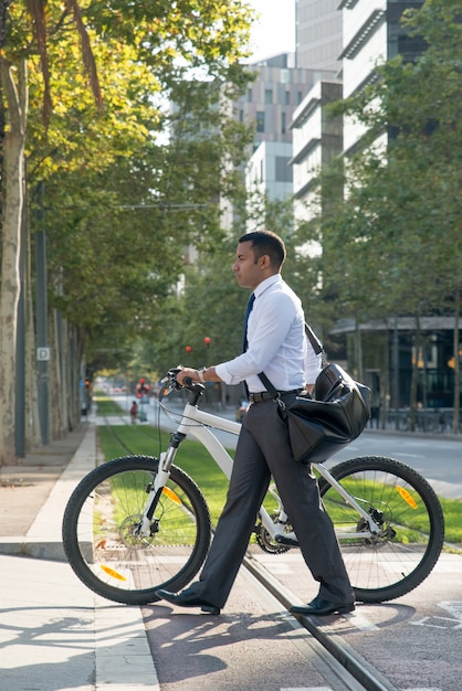 Modern businessman using bike for transportation