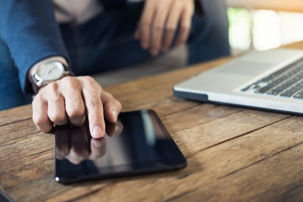 Modern businessman with tablet computer reading news at morning in cafe