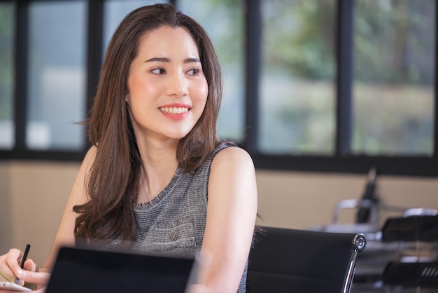 Modern businesswoman at the office, smiling female boss posing for a company photograph, self-assured successful woman at work