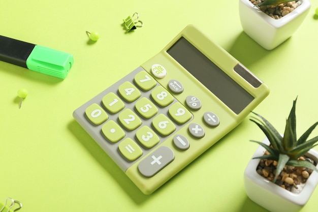 Photo modern calculator and stationery on color surface