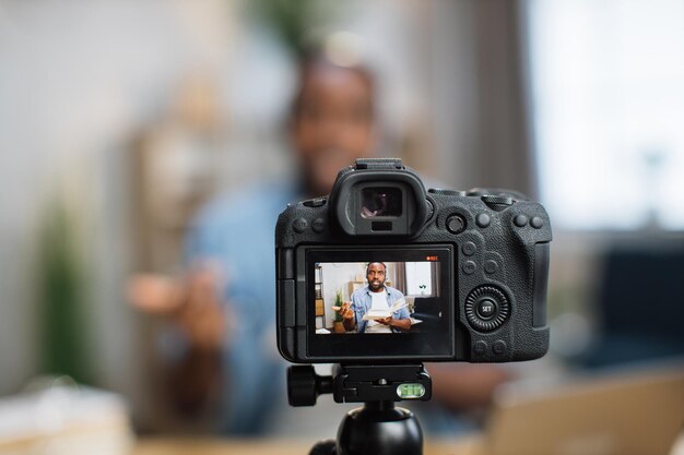 Modern camera with african american tutor on screen