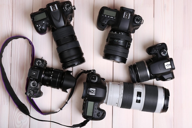 Photo modern cameras on wooden table top view