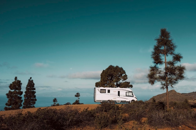 Modern camper van motorhome parked in the nature with sky view Concept of people and travel vehicle vacation Adventure vanlife lifestyle and nomadic life Summer campsite holiday