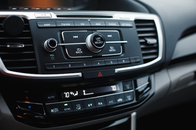 Pannello di controllo del clima per auto moderno per conducente e passeggero con profondità di campo ridotta climatizzatore a zone dettagli interni auto comandi radio cd multimediali multimedia