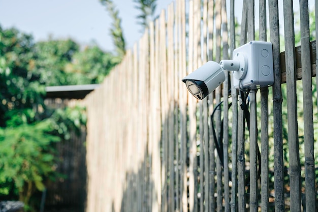 庭の木製の壁の背景にある最新のCCTVセキュリティシステムスマートカメラの盗難防止