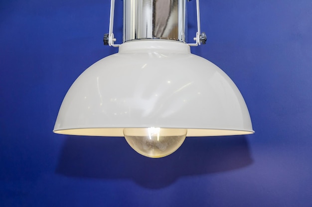 Modern chandelier hangs against dark blue wall Dim lamp light hanging lamp decor for room office